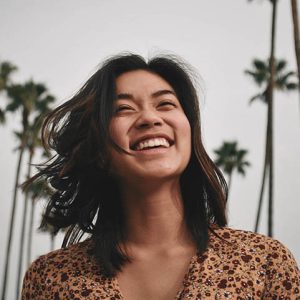 Image of Girl Smiling with Palm Trees in Background